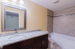 Bathroom featuring a dark wood-finish vanity with a white countertop and integrated sink - 
