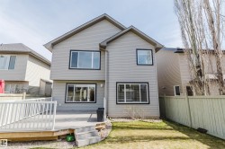 Rear exterior featuring light grey siding with black trim windows - 