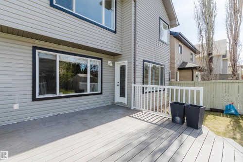 Grey composite deck with white railing, featuring a rear exterior with horizontal siding and black-trimmed windows - 1140 115 Street, Edmonton, AB - Outdoor With Deck Patio Veranda With Exterior
