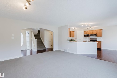 Open-concept living area featuring light gray carpeting and an arched entryway - 1140 115 Street, Edmonton, AB - Indoor Photo Showing Kitchen