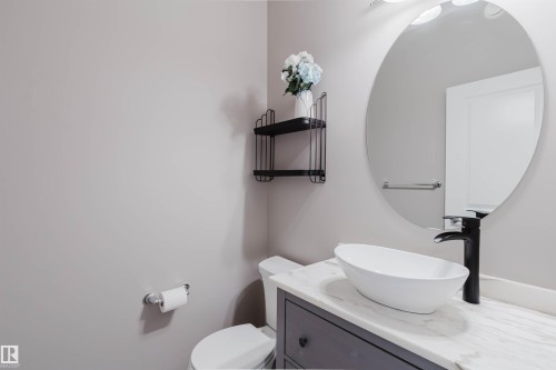 Bathroom featuring a gray vanity with a white countertop, a black faucet, and an oval vessel sink - 7827 18 Avenue, Edmonton, AB - Indoor Photo Showing Bathroom