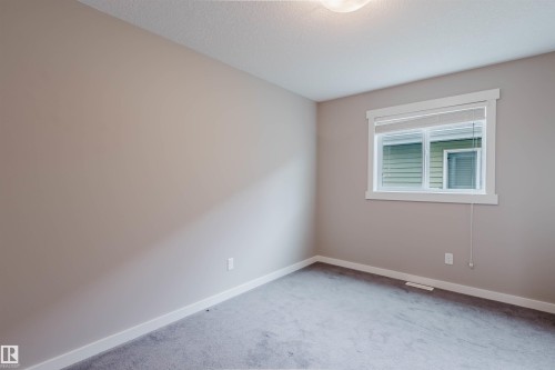 Neutral-toned walls complement the gray carpet flooring - 7827 18 Avenue, Edmonton, AB - Indoor Photo Showing Other Room