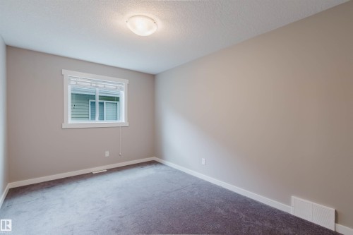 Neutral tone walls with white trim, a double-pane window, and a flush mount ceiling light - 7827 18 Avenue, Edmonton, AB - Indoor Photo Showing Other Room
