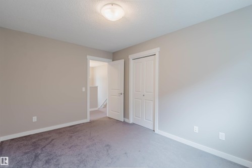 Spacious room featuring neutral painted walls, gray carpeting, white baseboards, and a flush mount ceiling light - 7827 18 Avenue, Edmonton, AB - Indoor Photo Showing Other Room