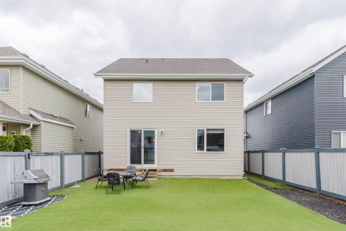 Rear exterior of a two-story residence featuring light beige siding - 7827 18 Avenue, Edmonton, AB - Outdoor With Exterior
