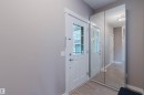 Entryway featuring light wood-finish flooring, white trim, and a full-height mirrored closet door - 7827 18 Avenue, Edmonton, AB  - Indoor Photo Showing Other Room 