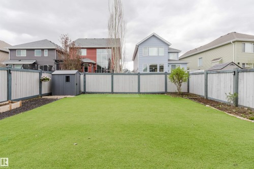 Spacious backyard featuring artificial turf, full perimeter fencing, a garden shed, and raised garden beds - 7827 18 Avenue, Edmonton, AB - Outdoor