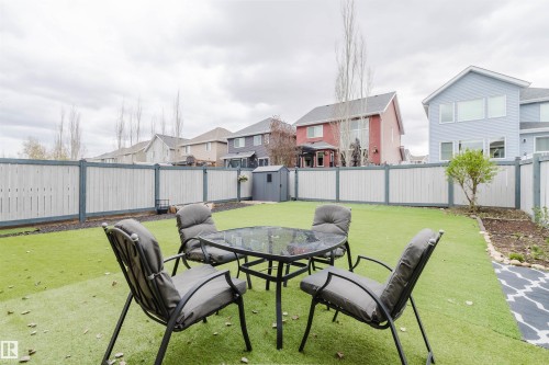Fenced backyard featuring artificial turf, a garden bed, and a storage shed - 7827 18 Avenue, Edmonton, AB - Outdoor