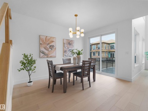Bright dining area featuring light wood-finish flooring, a modern gold-finish chandelier, and white baseboards - 43 Eldridge Point(E), St. Albert, AB - Indoor Photo Showing Dining Room