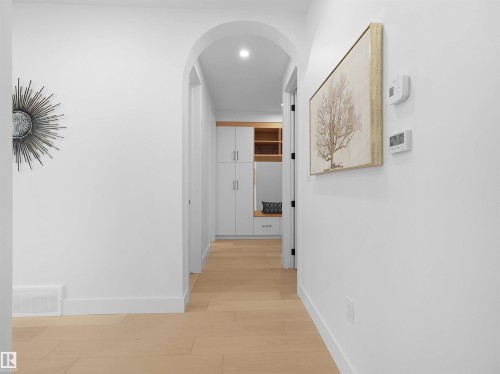 Archway entry featuring recessed lighting, light wood-finish flooring, and built-in white cabinetry with wood-tone accents - 43 Eldridge Point(E), St. Albert, AB - Indoor Photo Showing Other Room