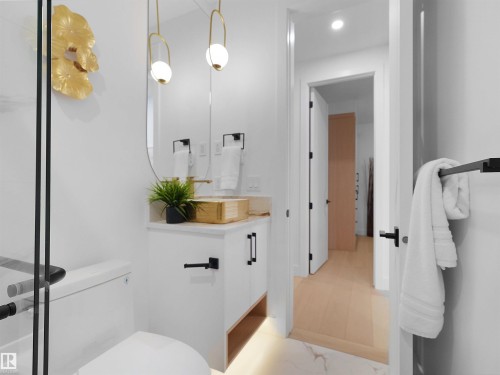Contemporary bathroom vanity featuring a gold vessel sink, white cabinetry with matte black hardware, and a gold wall-mounted faucet - 43 Eldridge Point(E), St. Albert, AB - Indoor Photo Showing Bathroom