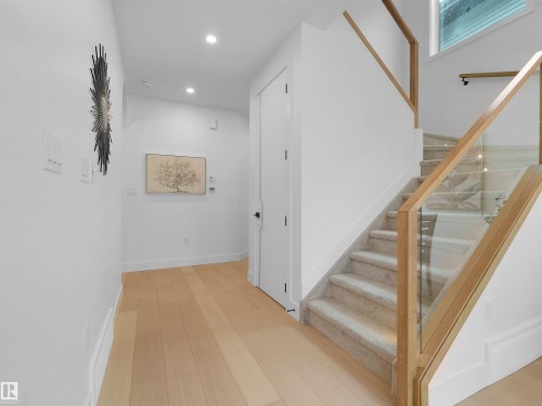 Modern staircase featuring wood-finish railings, glass panels, and carpeted treads - 43 Eldridge Point(E), St. Albert, AB - Indoor Photo Showing Other Room