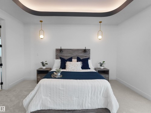 Recessed tray ceiling with cove lighting and two gold-finish pendant light fixtures - 43 Eldridge Point(E), St. Albert, AB - Indoor Photo Showing Bedroom
