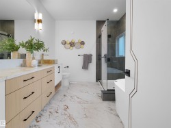 Contemporary bathroom featuring a light wood-finish vanity with a stone countertop, a gold vessel sink, and an enclosed glass shower - 