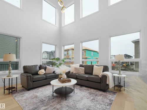 Two-story living area featuring a vaulted ceiling and an array of large windows - 43 Eldridge Point(E), St. Albert, AB - Indoor Photo Showing Living Room