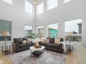 Two-story living area featuring a vaulted ceiling and an array of large windows - 43 Eldridge Point(E), St. Albert, AB  - Indoor Photo Showing Living Room 