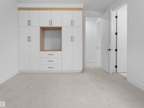 Built-in cabinetry with white flat-panel doors, black hardware, and wood-finish accents - 43 Eldridge Point(E), St. Albert, AB - Indoor Photo Showing Other Room