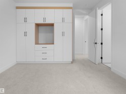Built-in cabinetry with white flat-panel doors, black hardware, and wood-finish accents - 