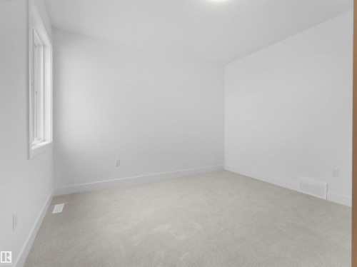 Bright interior space featuring a window with white trim, light-toned carpeting, white walls, and white baseboards - 43 Eldridge Point(E), St. Albert, AB - Indoor Photo Showing Other Room