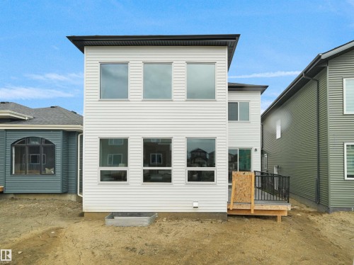 Contemporary rear exterior featuring white horizontal siding, a black soffit, and multiple large windows - 43 Eldridge Point(E), St. Albert, AB - Outdoor With Exterior