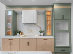 Contemporary kitchen featuring two-tone cabinetry with light wood-finish lower cabinets and sage green upper cabinets - 