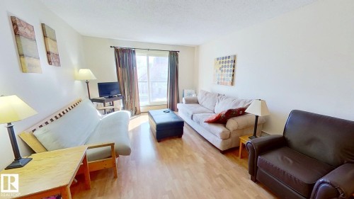 Living area featuring light wood-finish flooring and neutral wall tones - 401 10326 117 Street, Edmonton, AB - Indoor Photo Showing Living Room