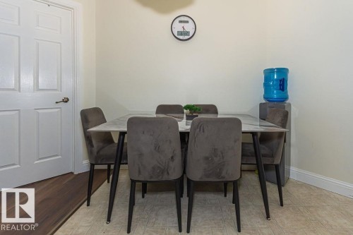 Dining area featuring a paneled interior door with bronze-finish hardware - 214 13005 140 Avenue, Edmonton, AB - Indoor