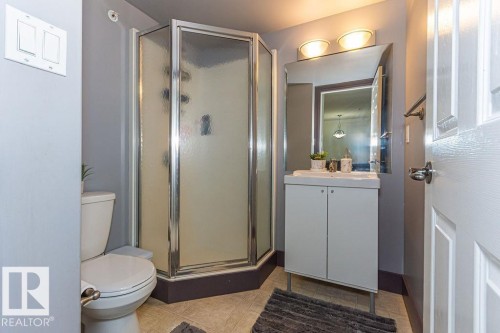 Bathroom with a corner shower enclosure featuring frosted glass panels and chrome trim - 214 13005 140 Avenue, Edmonton, AB - Indoor Photo Showing Bathroom