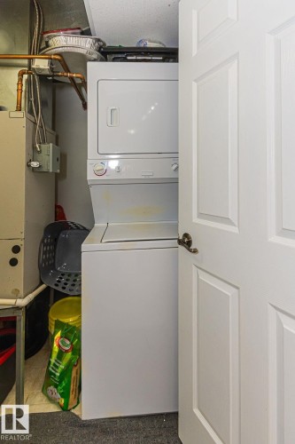 White stackable washer and dryer unit - 214 13005 140 Avenue, Edmonton, AB - Indoor Photo Showing Laundry Room