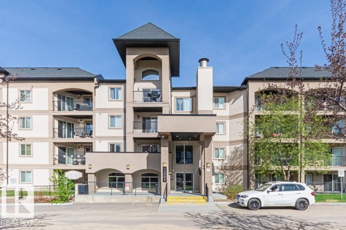 Multi-story apartment building featuring a prominent central entrance and a mix of private balconies - 214 13005 140 Avenue, Edmonton, AB - Outdoor With Facade
