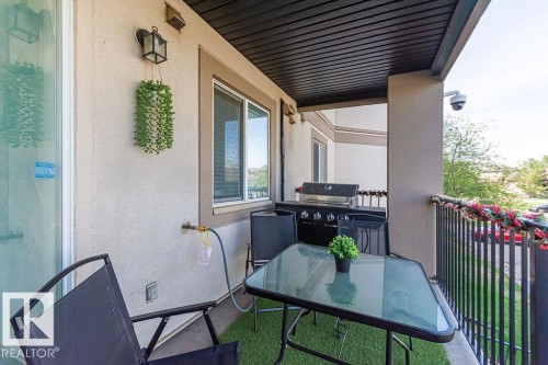 Outdoor balcony with stucco exterior, a black metal railing, and a dark soffit - 214 13005 140 Avenue, Edmonton, AB - Outdoor With Deck Patio Veranda With Exterior