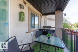 Outdoor balcony with stucco exterior, a black metal railing, and a dark soffit - 