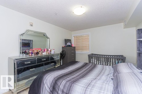 Neutral wall color with a window featuring horizontal blinds - 214 13005 140 Avenue, Edmonton, AB - Indoor Photo Showing Bedroom