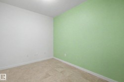 Neutral-toned tile flooring complements a green accent wall and crisp white baseboards - 