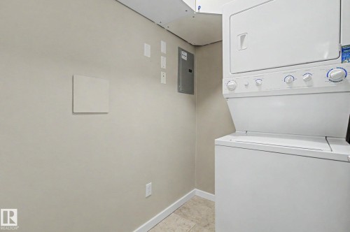 Dedicated laundry area featuring a stacked washer and dryer unit - 204 278 Suder Greens Drive, Edmonton, AB - Indoor Photo Showing Laundry Room