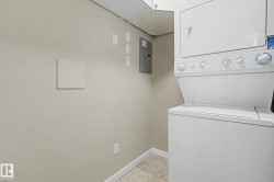 Dedicated laundry area featuring a stacked washer and dryer unit - 