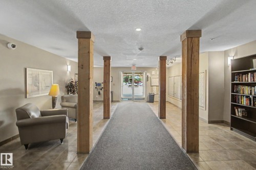 Central hallway with wood pillars and tile flooring - 204 278 Suder Greens Drive, Edmonton, AB - Indoor Photo Showing Other Room