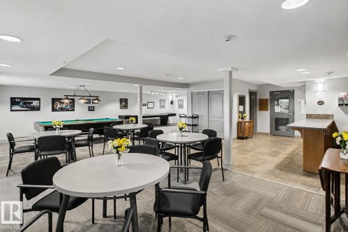 Recreational room featuring a billiards table, multiple seating areas with round and oval tables, recessed ceiling lights, a tiled entry area, and a built-in counter space - 204 278 Suder Greens Drive, Edmonton, AB - Indoor Photo Showing Dining Room
