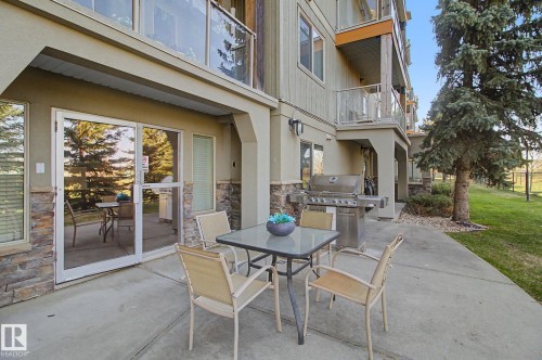 Expansive ground-level patio featuring a concrete surface and direct access to interior spaces through sliding glass doors - 204 278 Suder Greens Drive, Edmonton, AB - Outdoor With Balcony