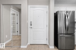 Entryway featuring a paneled door with smart lock hardware, mirrored closet doors, and tile flooring - 