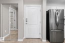 Entryway featuring a paneled door with smart lock hardware, mirrored closet doors, and tile flooring - 204 278 Suder Greens Drive, Edmonton, AB  - Indoor Photo Showing Other Room 