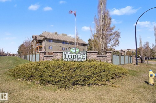 Stone-clad property entrance sign with integrated landscaping - 204 278 Suder Greens Drive, Edmonton, AB - Outdoor