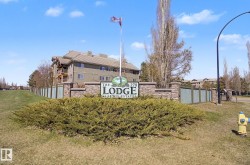 Stone-clad property entrance sign with integrated landscaping - 