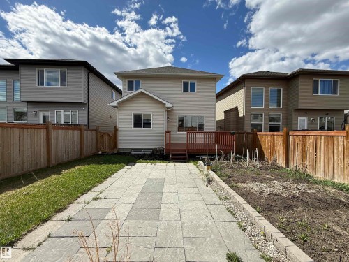 Expansive backyard featuring a concrete paver patio, a raised garden bed, and a wooden privacy fence - 4875 Wright Drive, Edmonton, AB - Outdoor