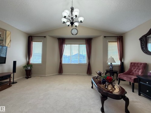 Living area with vaulted ceiling and central chandelier - 1764 Melrose Crescent, Edmonton, AB 