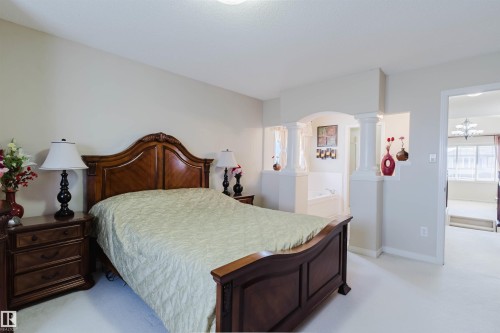 Bedroom featuring a decorative wood bed frame, light-colored walls, and a carpeted floor - 1764 Melrose Crescent, Edmonton, AB 