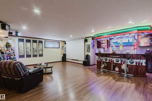 Entertainment space featuring wood-finish flooring, recessed lighting, and a built-in bar with accent lighting - 1764 Melrose Crescent, Edmonton, AB 