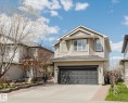 Two-story residential exterior featuring beige siding, white trim, and a dark asphalt shingle roof - 1764 Melrose Crescent, Edmonton, AB 