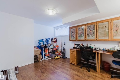 Wood-finish flooring with a built-in wood desk and overhead cabinetry - 1764 Melrose Crescent, Edmonton, AB 