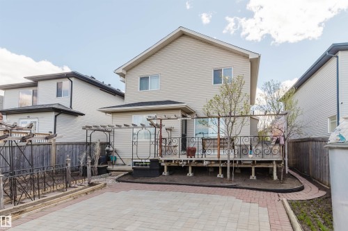 Rear exterior featuring light-colored siding, a dark shingle roof, and multiple windows - 1764 Melrose Crescent, Edmonton, AB 